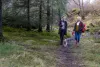 Zwei Frauen gehen zusammen mit Hund durch den Wald
